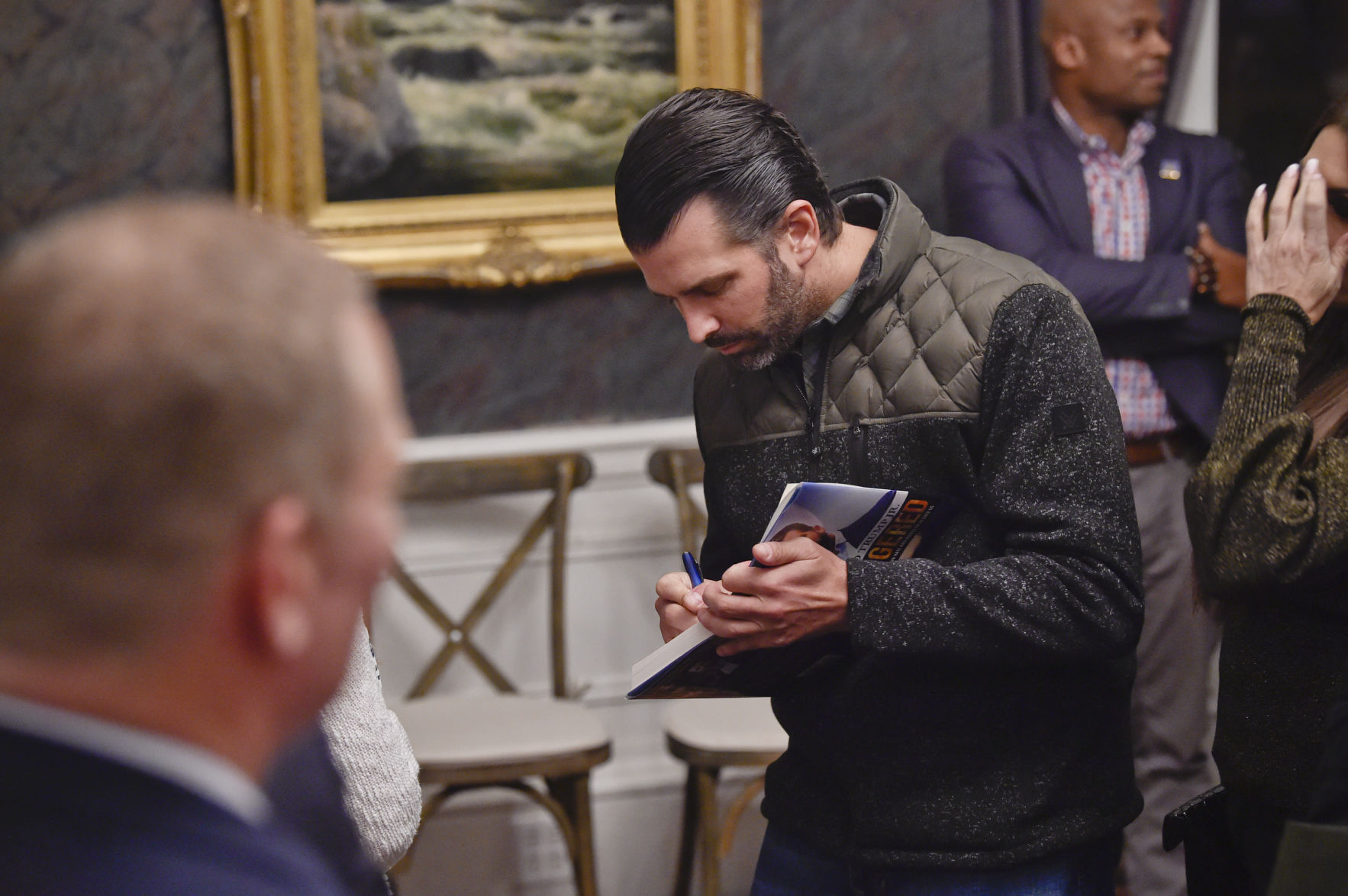 Donald Trump Jr. signs a copy of his book "Triggered" f